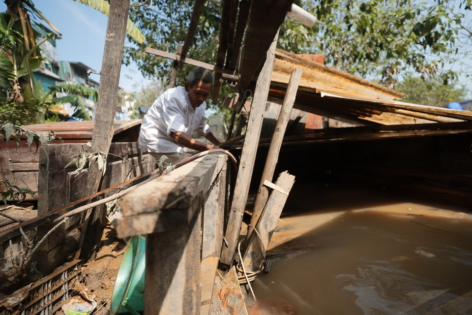 Một người dân sửa lại chuồng gà bị nước ngập làm hỏng. (Ảnh: Minh Quyết/TTXVN)