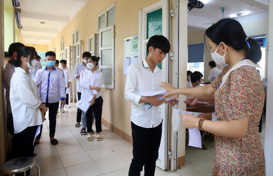  Cán bộ coi thi tại Hội đồng coi thi THPT Thanh Thủy, tỉnh Phú Thọ gọi thí sinh vào phòng thi. (Ảnh: Trung Kiên/TTXVN)