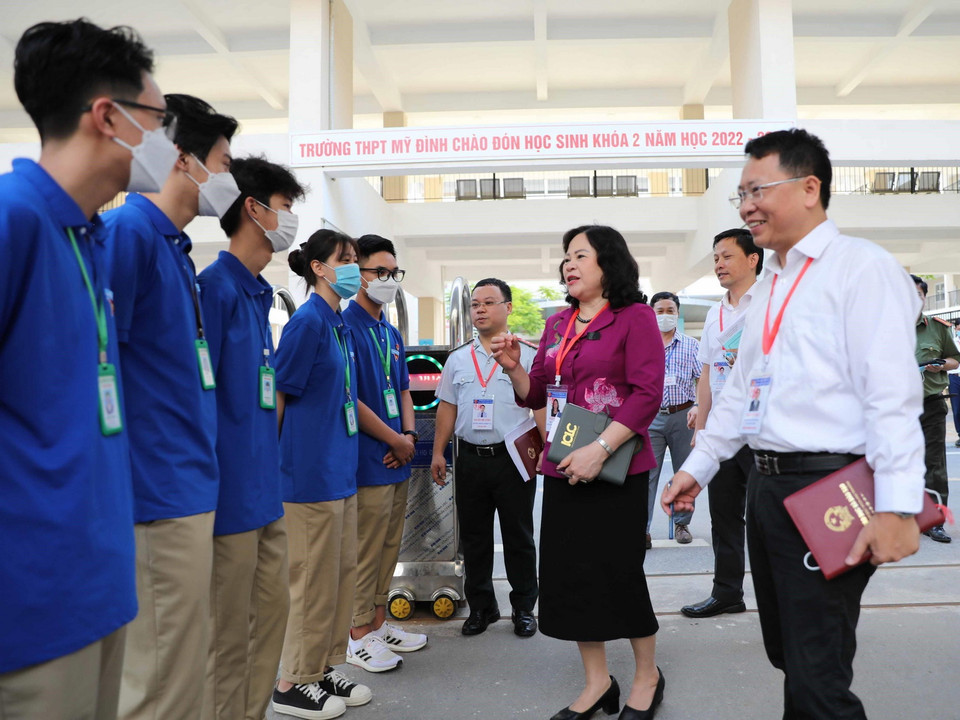 Thứ trưởng Bộ Giáo dục và Đào tạo Ngô Thị Minh hỏi thăm, động viên các tình nguyện viên tại điểm thi trường THPT Mỹ Đình, Hà Nội. (Ảnh: Thanh Tùng/TTXVN)