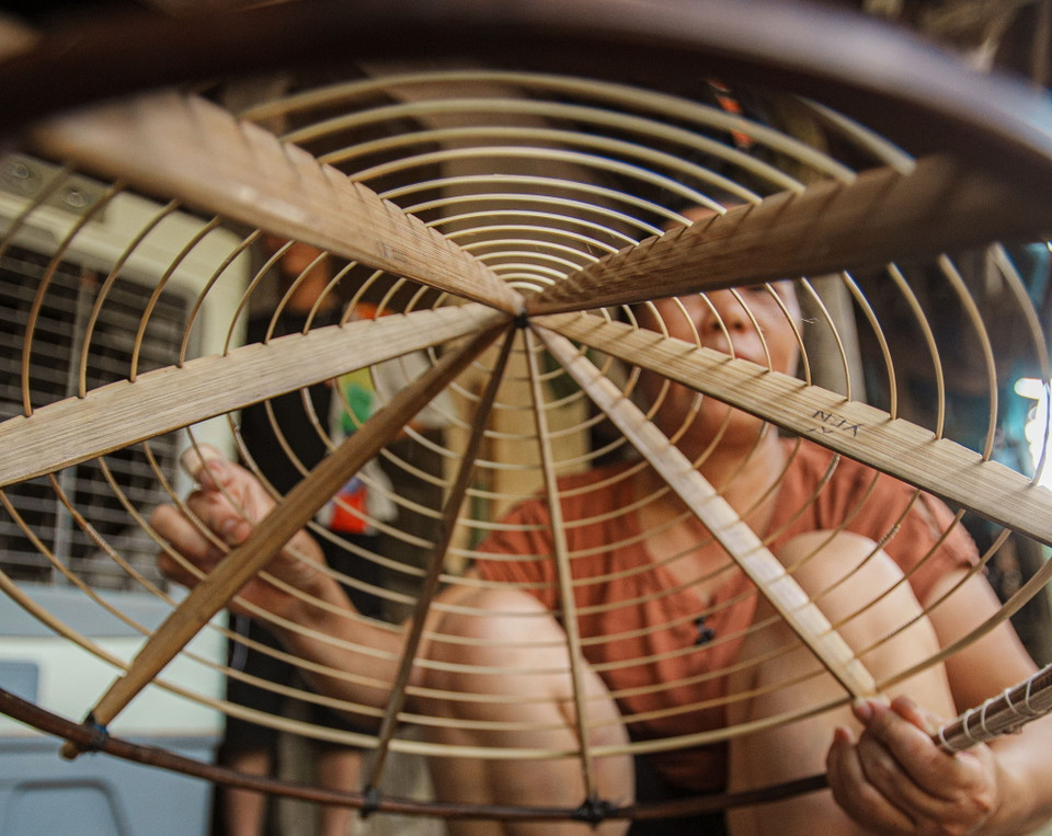Đặc điểm khác biệt của nón làng Chuông là nón có 16 vòng, vòng ngoài cùng to nhất, rộng nhất, các vòng sau nhỏ dần theo hình khuôn nón. "Chiếc nón thành phẩm phải chứa cả ba lớp lá: Lớp lá lót, mo nứa, sau đến lớp lá ngoài, khi cầm lên vẫn phải thấy mỏng mà nhẹ thì mới là nón đẹp. (Ảnh: Phạm Tuấn Anh/TTXVN)