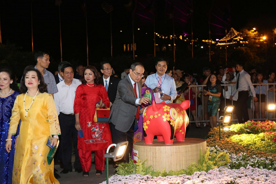 Bí thư Thành ủy Thành phố Hồ Chí Minh Nguyễn Thiện Nhân bỏ ống nuôi heo đất Tết làm điều hay, chung tay đóng góp cho học sinh nghèo Thành phố Hồ Chí Minh tại Đường hoa Tết Kỷ Hợi 2019. (Ảnh: Thanh Vũ/TTXVN)