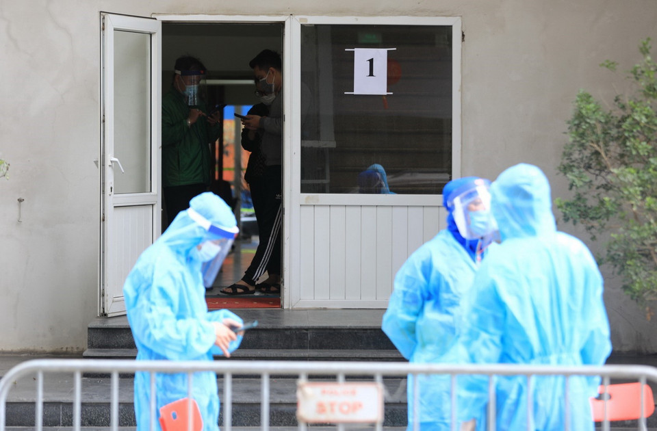 Lối lên của tòa nhà N03 được bố trí nhân viên chức năng trang bị áo bảo hộ kiểm soát việc ra vào tòa nhà và tiếp nhận đồ từ bên ngoài. (Ảnh: Thành Đạt/TTXVN)