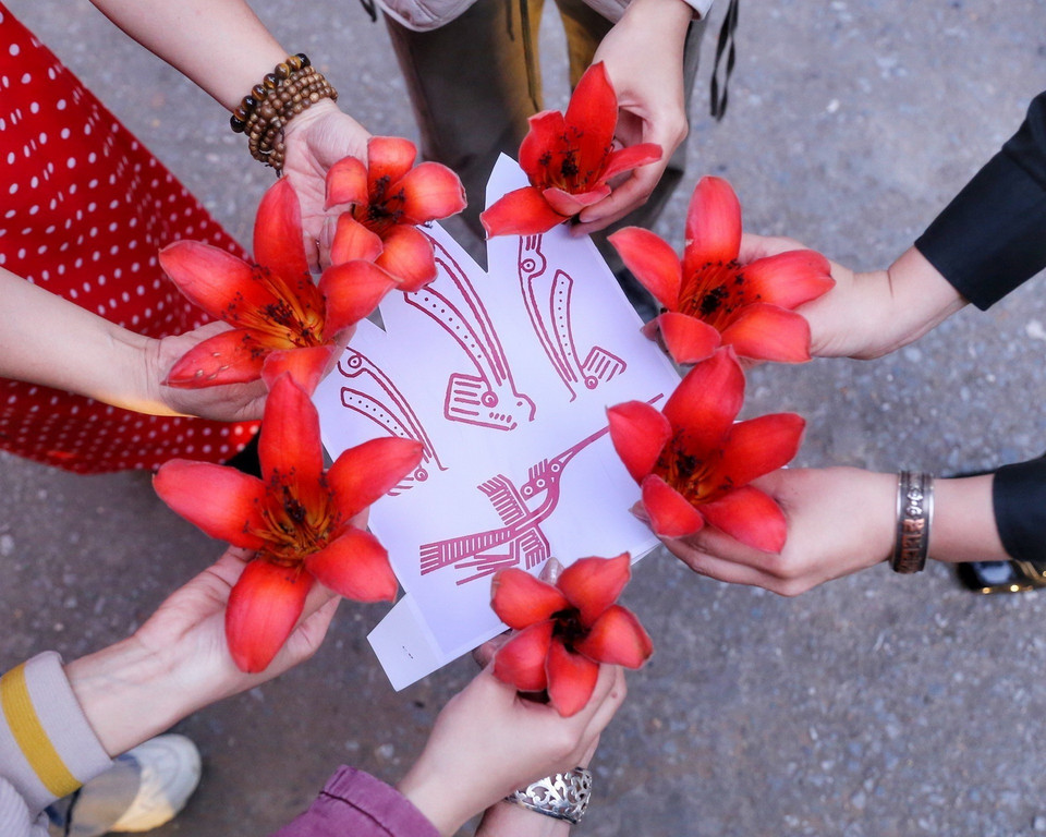 Du khách tạo hình chụp ảnh với hoa gạo. (Ảnh: Tuấn Đức/TTXVN)