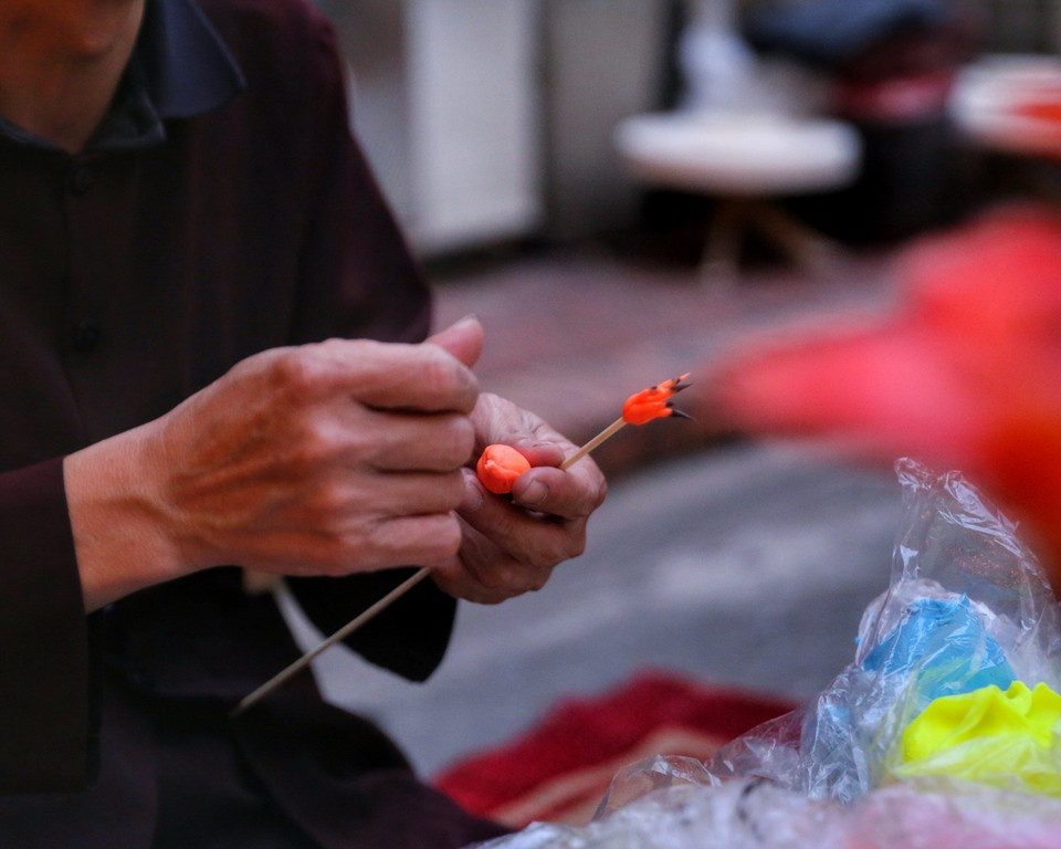 Nghệ nhân làm tò he hình hoa gạo. (Ảnh: Tuấn Đức/TTXVN)