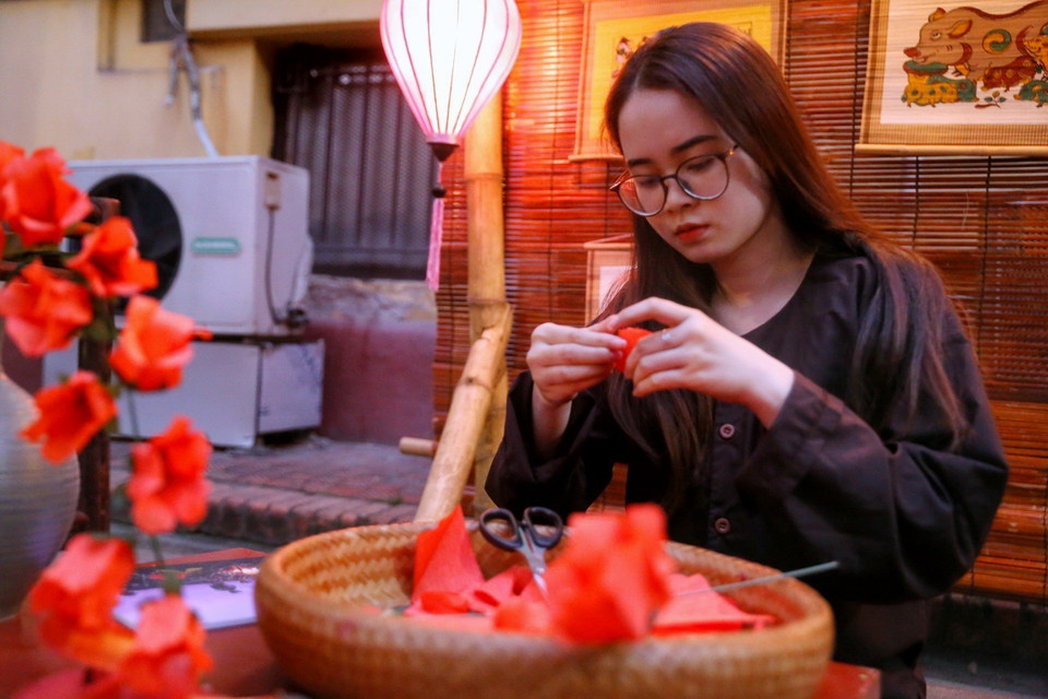 Nghệ nhân gấp hoa gạo bằng giấy. (Ảnh: Tuấn Đức/TTXVN)