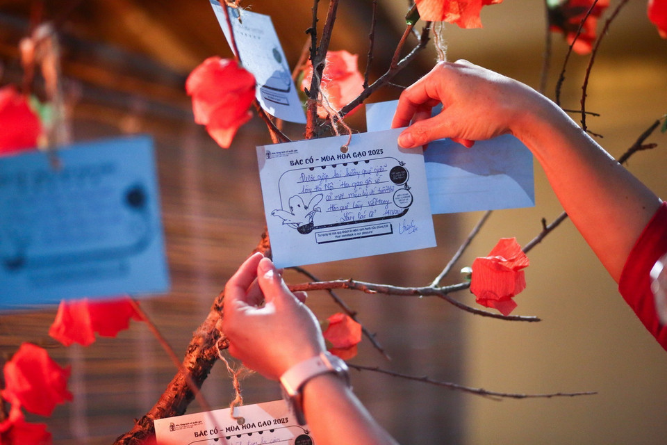 Du khách viết thông điệp treo lên cây hoa gạo giấy. (Ảnh: Thu Phương/TTXVN phát)