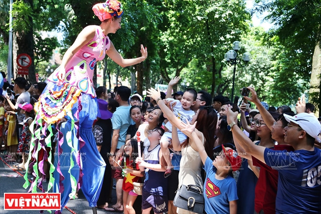 Nữ diễn viên xiếc trên chiếc cà kheo cao lênh khênh giao lưu với khán giả. (Ảnh: Công Đạt/Báo Ảnh Việt Nam)