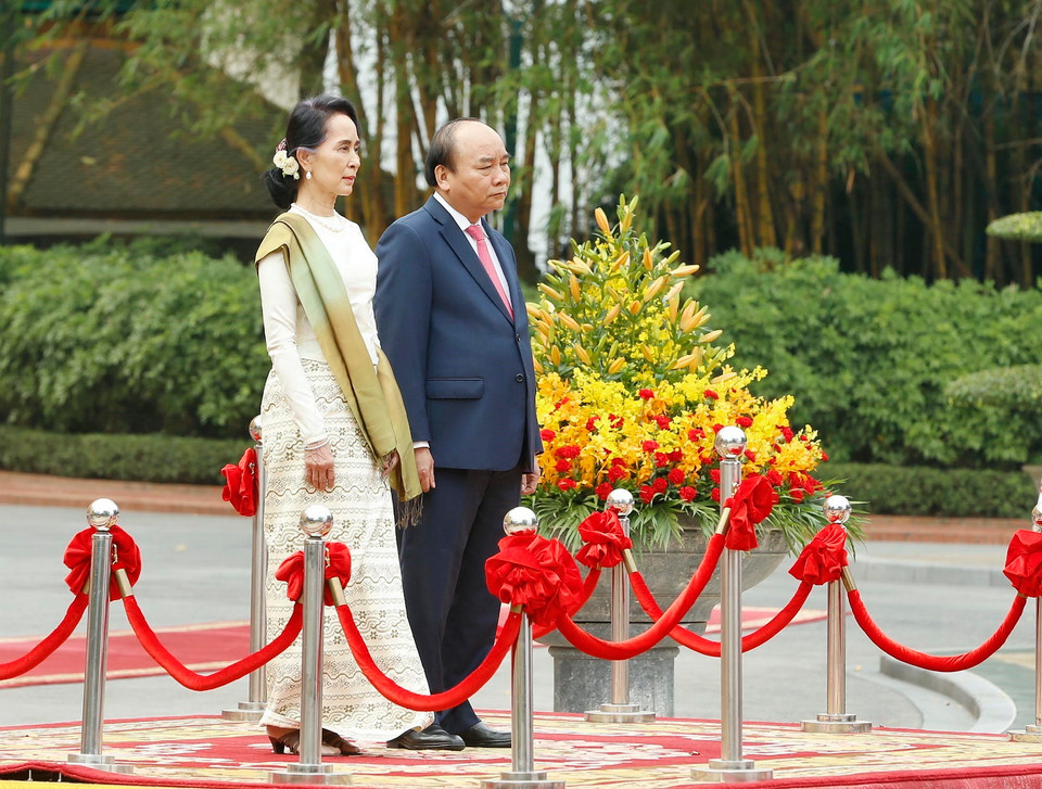 Thủ tướng Nguyễn Xuân Phúc và Cố vấn Nhà nước, Bộ trưởng Ngoại giao và Bộ trưởng Văn phòng Tổng thống nước CHLB Myanmar Aung San Suu Kyi trên bục danh dự, thực hiện nghi thức chào cờ. (Ảnh: Dương Giang/TTXVN)