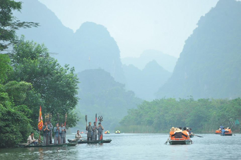 Tái hiện hình ảnh vua quan và lính dọc hai bên bờ sông đón chào đại biểu và khách du lịch về khai hội. (Ảnh: Minh Đức/TTXVN)