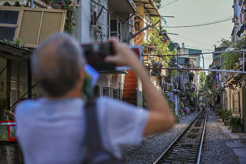 Du khách thích thú ghi lại những hình ảnh của "phố đường tàu" khi ghé đến nơi đây. (Ảnh: Trọng Đạt/TTXVN)