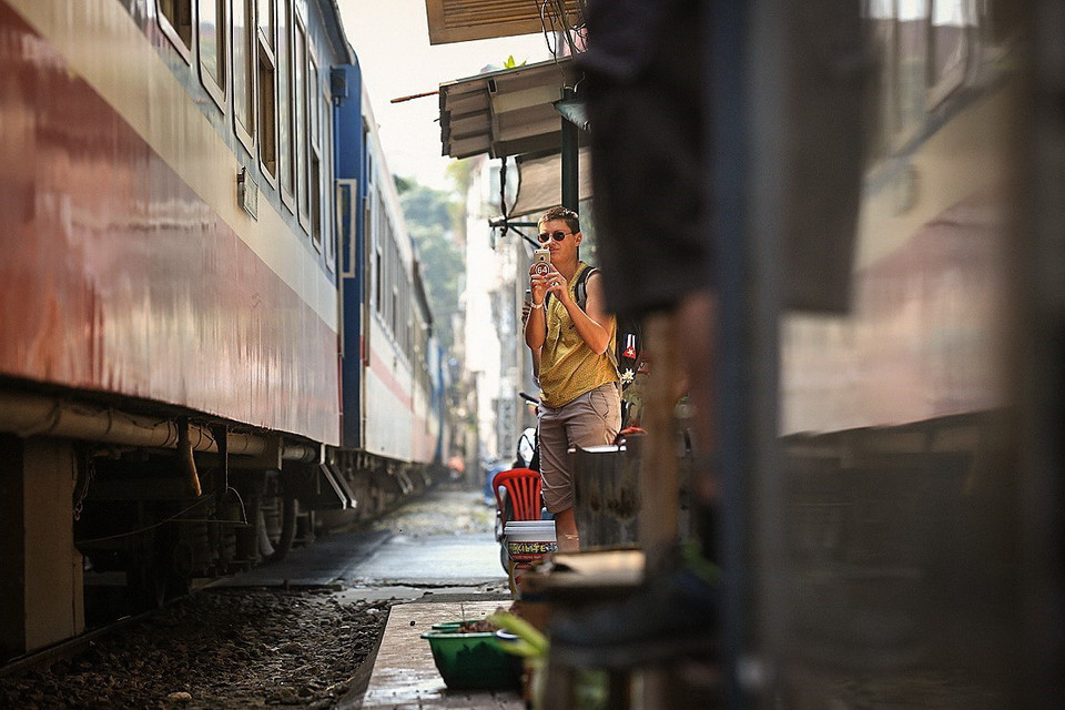 Du khách lưu lại những khoảng khắc khi đoàn tàu Thống Nhất chậm rãi tiến vào Phố đường tàu. (Ảnh: Trọng Đạt/TTXVN)