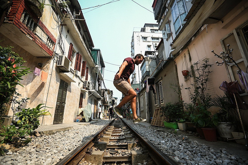 Khách du lịch là người nước ngoài thích thú thể hiện những bước nhảy qua đường ray khi đến thăm phố đường tàu. (Ảnh: Trọng Đạt/TTXVN)