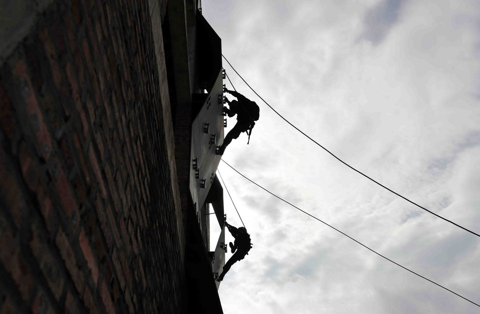 Đu dây đột nhập, tấn công tội phạm ở nhà cao tầng là nội dung thường thấy ở lực lượng cảnh sát đặc nhiệm. Đây là nội dung đòi hỏi sự khéo léo, bản lĩnh và phối hợp nhịp nhàng giữa các thành viên trong đội. (Ảnh: Phạm Kiên/TTXVN)