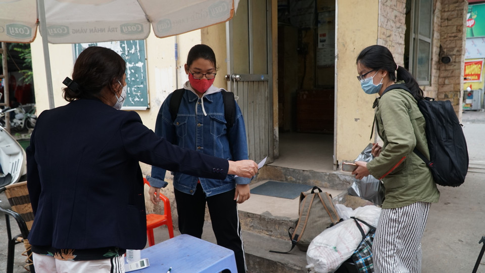 Trường này cũng bố trí người tại các khu nhà, cổng vào để kiểm tra thân nhiệt của các sinh viên. (Ảnh: PV/Vietnam+)