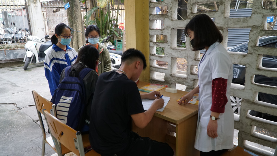 Kiểm tra thân nhiệt và khai báo tại trạm y tế trường Đại học Kinh tế quốc dân. (Ảnh: PV/Vietnam+)