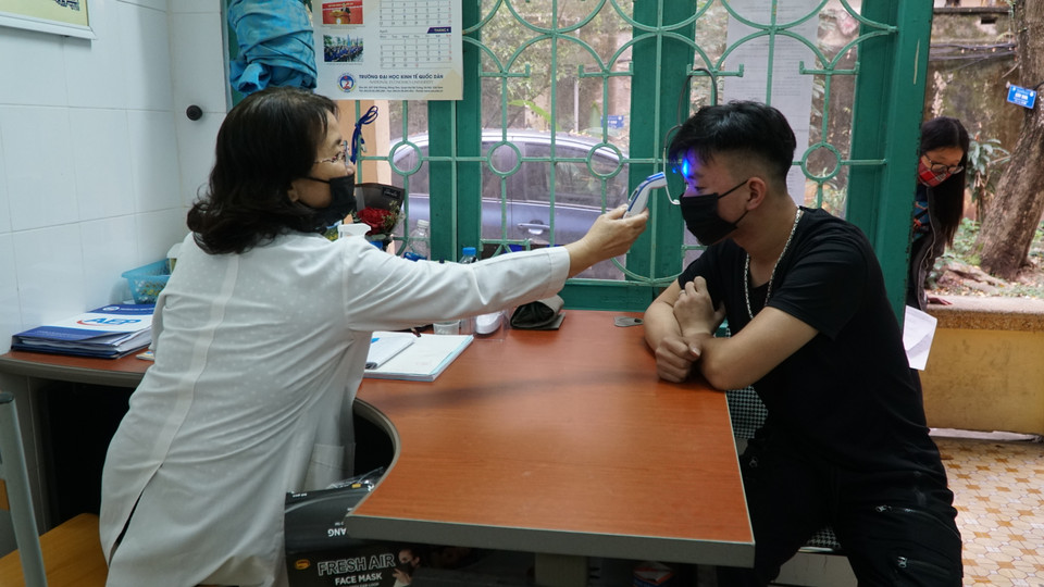 Kiểm tra thân nhiệt và khai báo tại trạm y tế trường Đại học Kinh tế quốc dân. (Ảnh: PV/Vietnam+)
