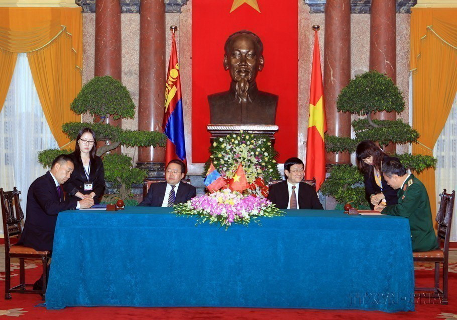 Chủ tịch nước Trương Tấn Sang và Tổng thống Mông Cổ Tsakhiagiin Elbegdorj chứng kiến lễ ký Bản ghi nhớ hợp tác trong lĩnh vực Quốc phòng giữa Bộ Quốc phòng hai nước năm 2013. (Ảnh: Nguyễn Khang/TTXVN)