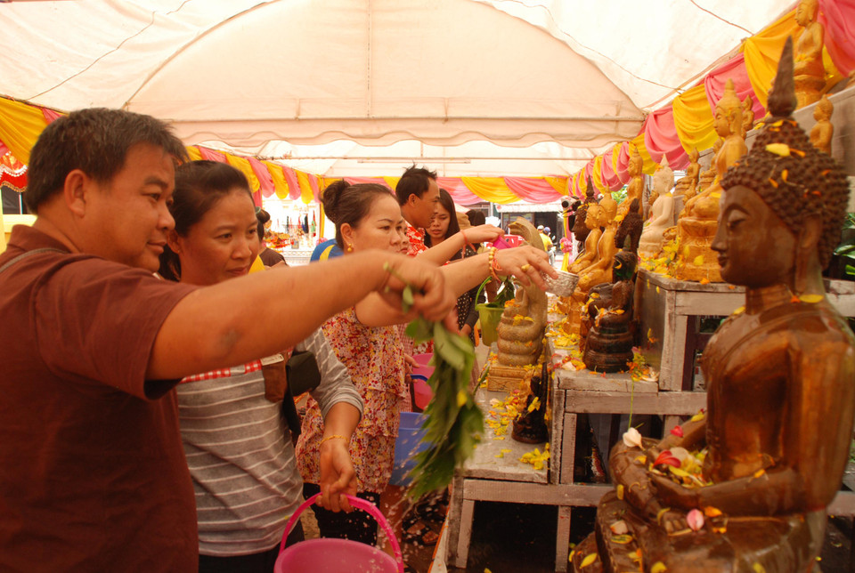 Cứ mỗi dịp đến Tết, người Lào thường cố gắng đến càng nhiều chùa càng tốt (ít nhất là 9 chùa) để tắm Phật. (Ảnh: Phạm Kiên/Vietnam+)