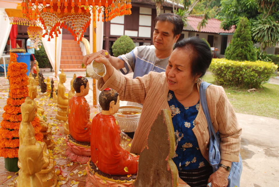 Theo quan niệm của người Lào, việc tắm Phật chính là tỏ lòng tôn trọng, là cách thức bày tỏ đức tin của mình đối với Đức Phật. (Ảnh: Phạm Kiên/Vietnam+)