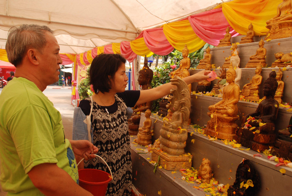 Người dân ở thủ đô Vientiane đang thực hiện nghi lễ tắm Phật tại chùa Impeng, một ngôi chùa lớn nằm ở trung tâm thủ đô. (Ảnh: Phạm Kiên/Vietnam+)