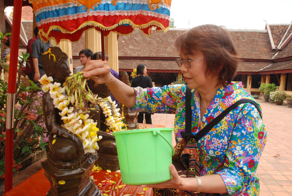 Khi thực hiện nghi thức tắm Tượng, người dân thường dùng hoa Chăm Pa (hoa Đại), hoặc hoa Khun (hoa may mắn) để tắm cho Phật. (Ảnh: Phạm Kiên/Vietnam+)