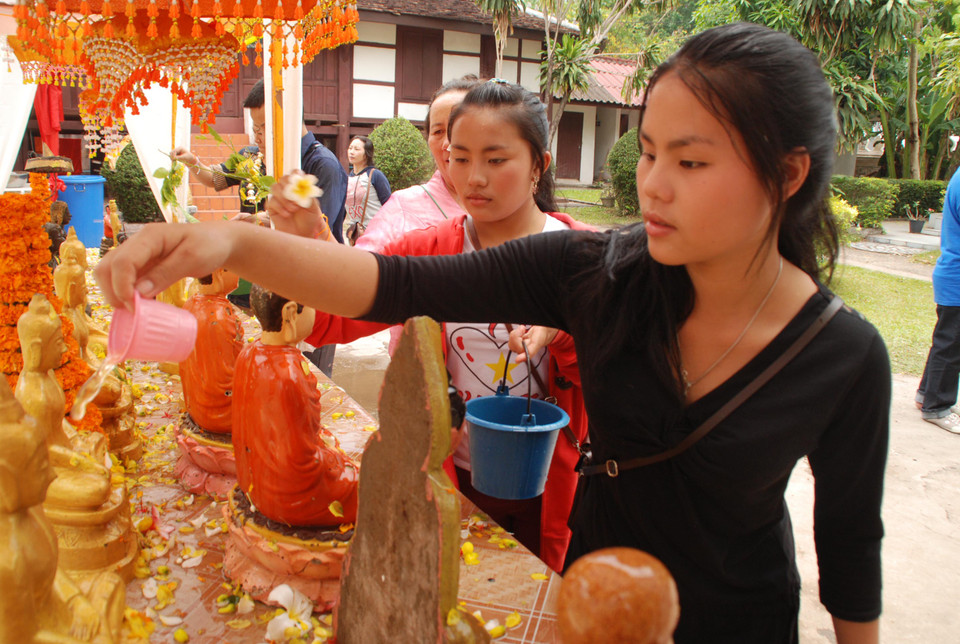 Việc đi chùa tắm Phật thu hút mọi tầng lớp nhân dân Lào từ già tới trẻ. (Ảnh: Phạm Kiên/Vietnam+)