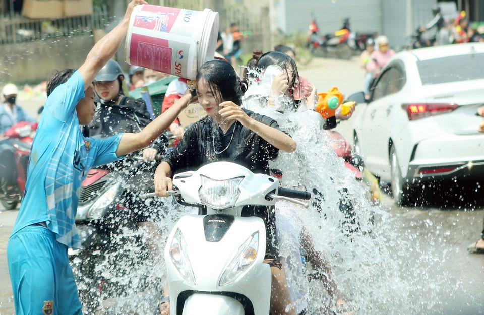 Mọi người thỏa sức té nước vào nhau, với mong muốn mọi điều không may sẽ được gột rửa để mang lại những điều may mắn nhất trong năm. (Ảnh: Quý Trung/TTXVN)