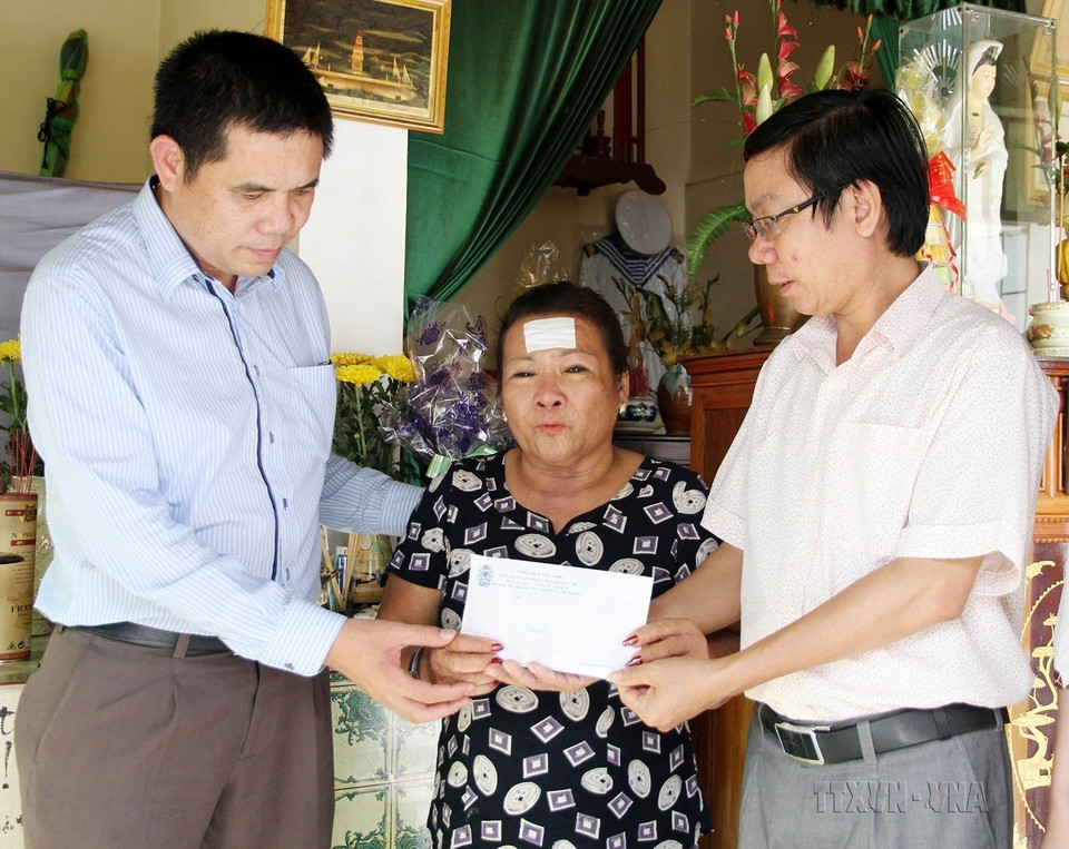 Đại diện Liên đoàn Lao động tỉnh Quảng Trị và Quỹ từ thiện xã hội Tấm lòng Vàng (Báo Lao Động) trao tiền hỗ trợ cho bà Nguyễn Thị Hằng, ở thành phố Đông Hà, tỉnh Quảng Trị, là mẹ liệt sỹ Hoàng Ánh Đông hy sinh trong trận chiến đấu bảo vệ Gạc Ma năm 1988. (Ảnh: Hồ Cầu/TTXVN)