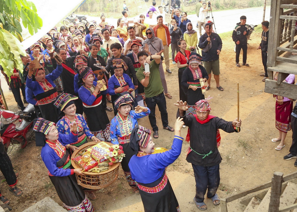  Đoàn người xin nước làm lễ só nặm phạ phốn (xin nước mưa) trước gia chủ. (Ảnh: Xuân Tư/TTXVN)