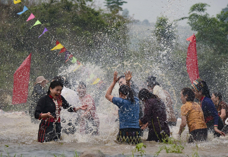  Đông đảo bà con dân bản và du khách cùng nhau ra suối vẩy nước vào nhau với mong muốn mọi người gặp nhiều may mắn. (Ảnh: Xuân Tư/TTXVN)