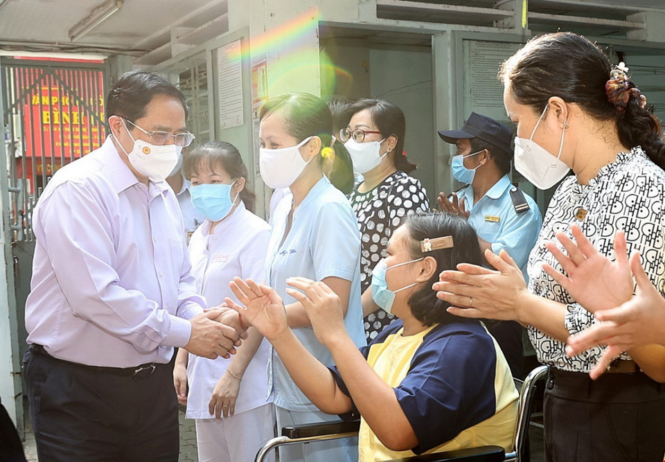  Thủ tướng Phạm Minh Chính cùng cán bộ, nhân viên và trẻ em đang được nuôi dưỡng, chăm sóc tại Trung tâm Bảo trợ trẻ tàn tật mồ côi Thị Nghè. (Ảnh: Dương Giang/TTXVN)
