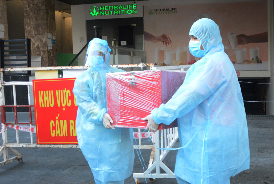 Sau khi cử tri bỏ phiếu xong, hòm phiếu nhanh chóng được xịt khử khuẩn và đưa ra xe. (Ảnh: Văn Dũng/TTXVN)