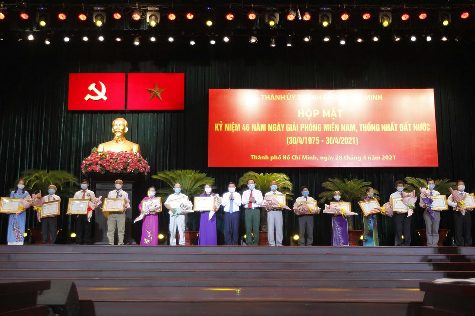 Bí thư Thành ủy Nguyễn Văn Nên và Chủ tịch UBND Thành phố Hồ Chí Minh Nguyễn Thành Phong truy tặng danh hiệu Bà Mẹ Việt Nam Anh hùng cho thân nhân các mẹ tại buổi họp mặt. (Ảnh: Thanh Vũ/TTXVN)