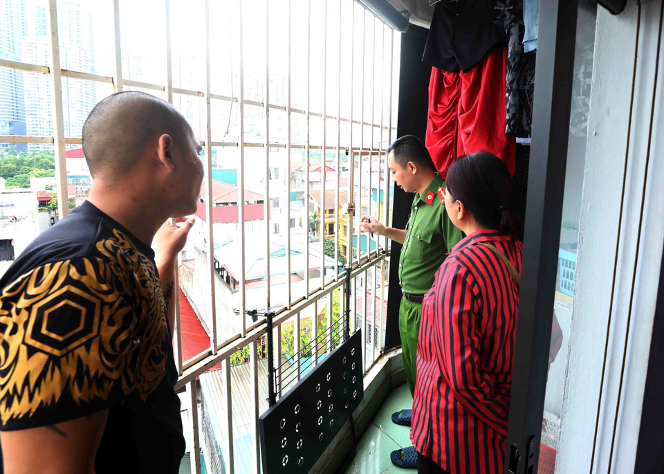 Công an quận Bắc Từ Liêm yêu cầu người dân sinh sống tại chung cư mini lắp đặt thang thoát hiểm và mở cửa thoát hiểm tại khu vực đã bị rào kín. (Ảnh: Phạm Kiên/TTXVN)