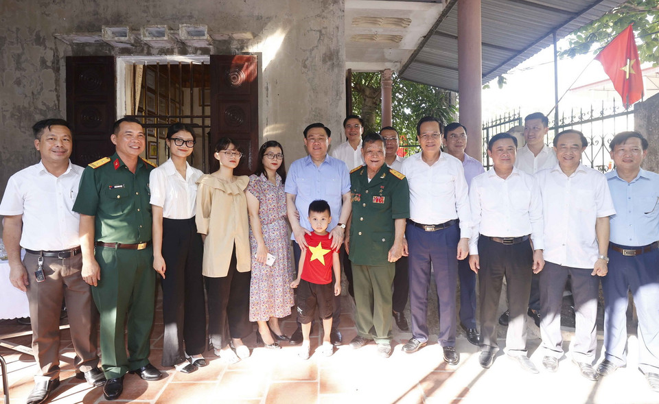 Chủ tịch Quốc hội Vương Đình Huệ chụp ảnh chung cùng gia đình Anh hùng lực lượng Vũ trang, thương binh 3/4 Đoàn Minh Nguyệt. (Ảnh: Doãn Tấn/TTXVN)