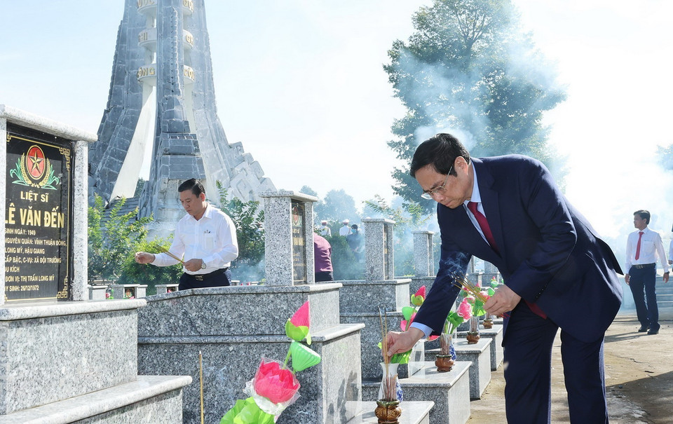 Thủ tướng đi thắp hương trên mộ liệt sỹ tại Nghĩa trang liệt sỹ tỉnh Hậu Giang. (Ảnh: Dương Giang/TTXVN) 