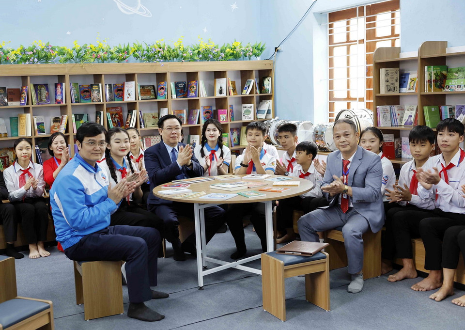 Chủ tịch Quốc hội Vương Đình Huệ với học sinh tại "Không gian đọc sách, tương tác và sinh hoạt Đội" của Trường Trung học Cơ sở Nam Thanh. (Ảnh: Nhan Sáng/TTXVN)