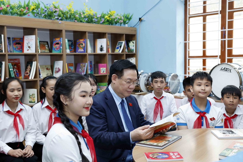 Chủ tịch Quốc hội Vương Đình Huệ đọc sách tại "Không gian đọc sách, tương tác và sinh hoạt Đội" của Trường Trung học cơ sở Nam Thanh. (Ảnh: Nhan Sáng/TTXVN)