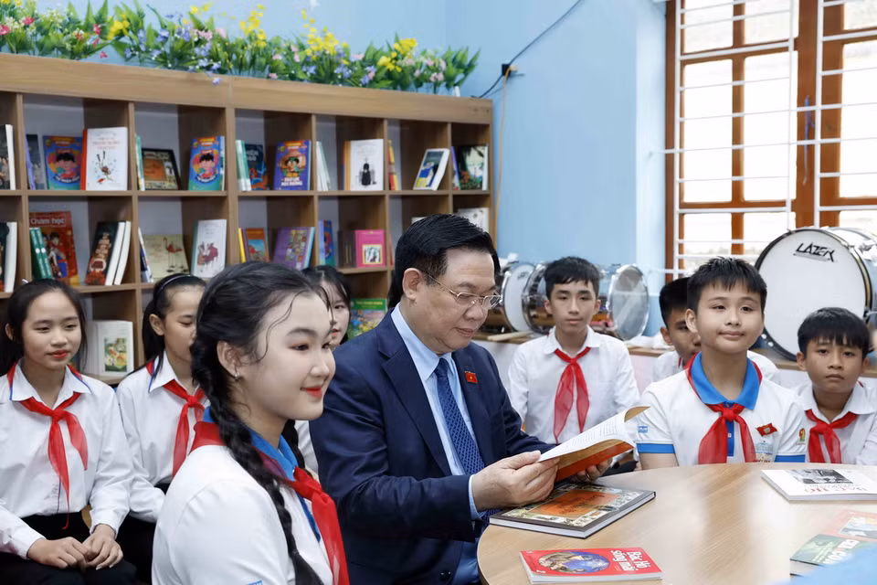Chủ tịch Quốc hội Vương Đình Huệ đọc sách tại "Không gian đọc sách, tương tác và sinh hoạt Đội" của Trường Trung học cơ sở Nam Thanh. (Ảnh: Nhan Sáng/TTXVN)