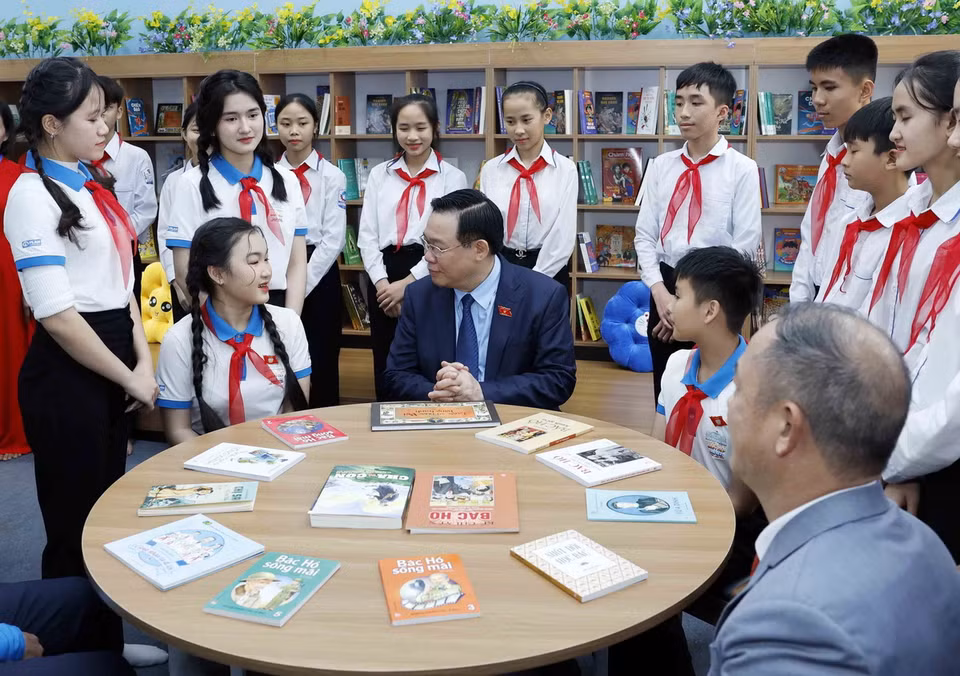 Chủ tịch Quốc hội Vương Đình Huệ trò chuyện với học sinh Trường THCS Nam Thanh. (Ảnh: Nhan Sáng/TTXVN)