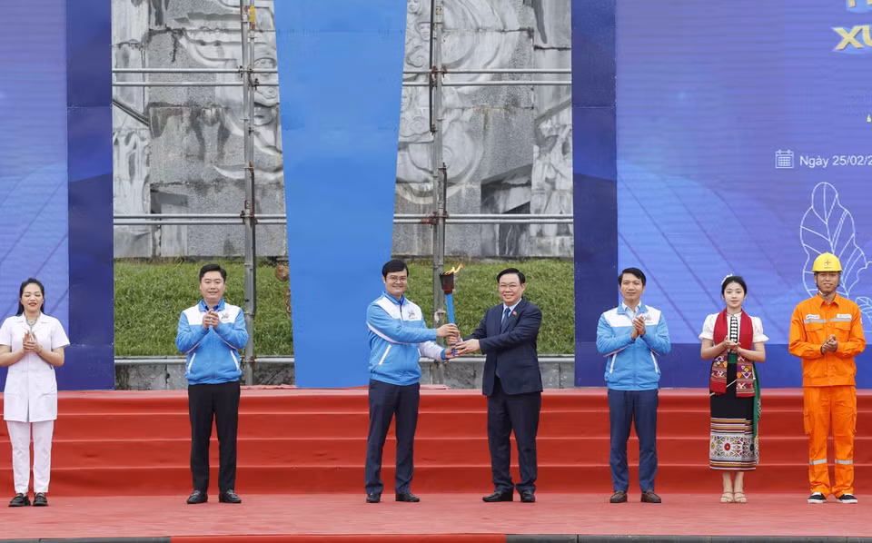 Chủ tịch Quốc hội Vương Đình Huệ giao ngọn đuốc tình nguyện, đại diện cho ý chí, khát vọng của tuổi trẻ cả nước cho Bí thư thứ nhất Trung ương Đoàn TNCS Hồ Chí Minh Bùi Quang Huy. (Ảnh: Nhan Sáng/TTXVN)