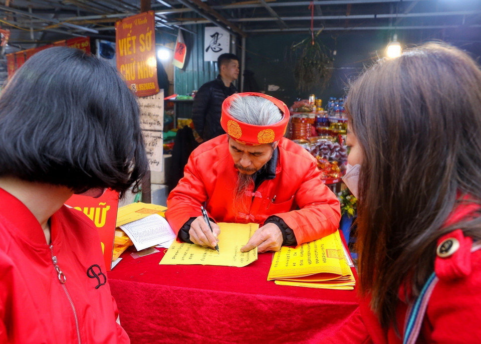 Người dân đi lễ và xin sớ đầu năm tại Phủ Tây Hồ.(Ảnh: Tuấn Đức/TTXVN)