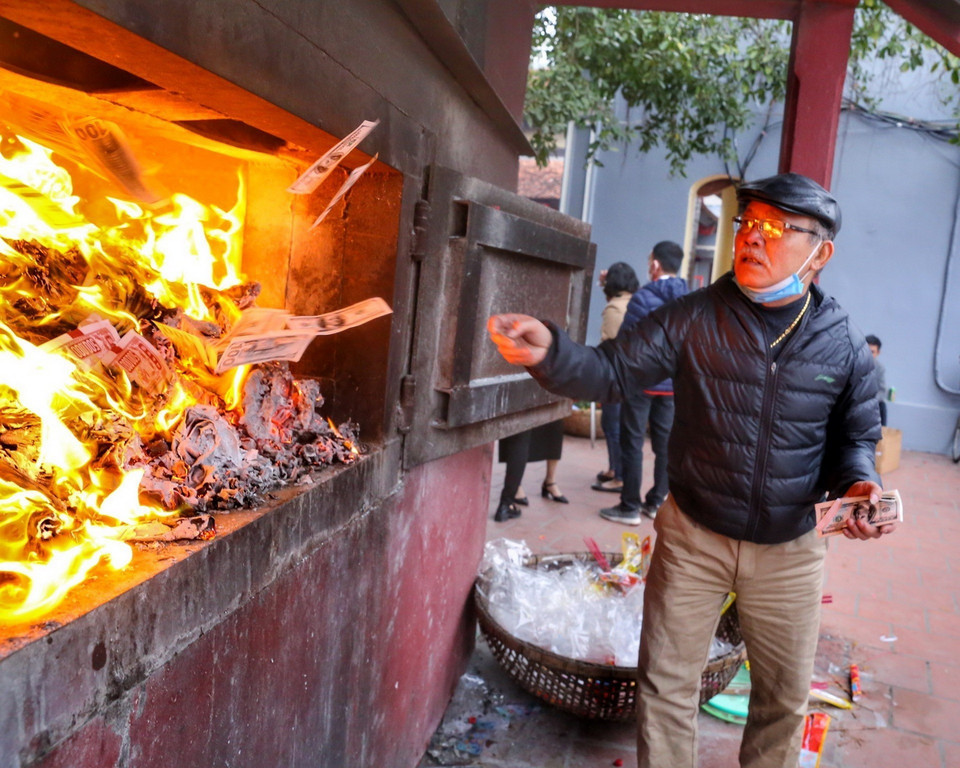 Người dân hóa vàng sau khi làm lễ tại Phủ Tây Hồ. (Ảnh: Tuấn Đức/TTXVN)