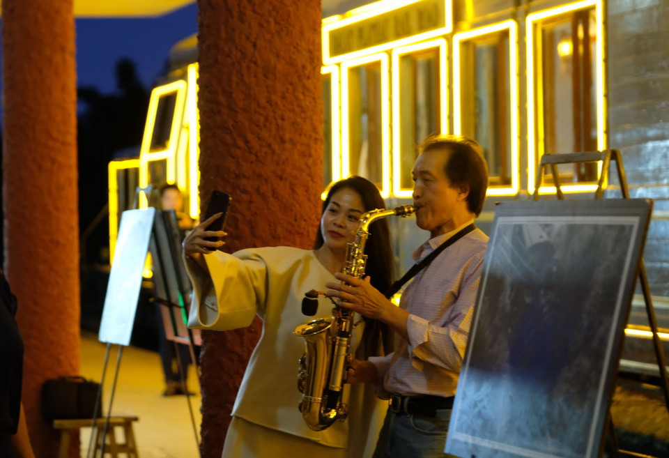 Du khách thích thú với màn trình diễn saxophone tại sân ga Đà Lạt trước giờ tàu hỏa khởi hành. (Ảnh: Nguyễn Dũng/TTXVN)