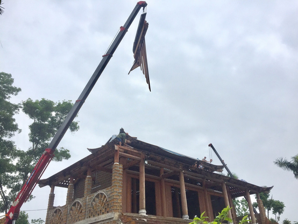 Tháo dỡ phần mái ''cung điện.'' (Ảnh: Minh Nghĩa/Vietnam+)