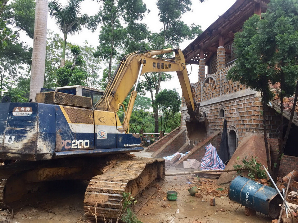 Lực lượng chức năng tiếp tục phá dỡ phần khu nhà chính 2 tầng của công trình vi phạm. (Ảnh: Minh Nghĩa/Vietnam+)