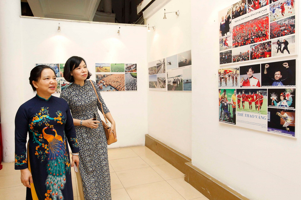 Bà Trần Thị Hà, Phó Chủ tịch thường trực Hội đồng Thi đua-Khen thưởng Trung ương, Thứ trưởng Bộ Nội vụ, Trưởng ban Ban Thi đua - Khen thưởng Trung ương và Phó Tổng giám đốc TTXVN Vũ Việt Trang tham quan triển lãm.