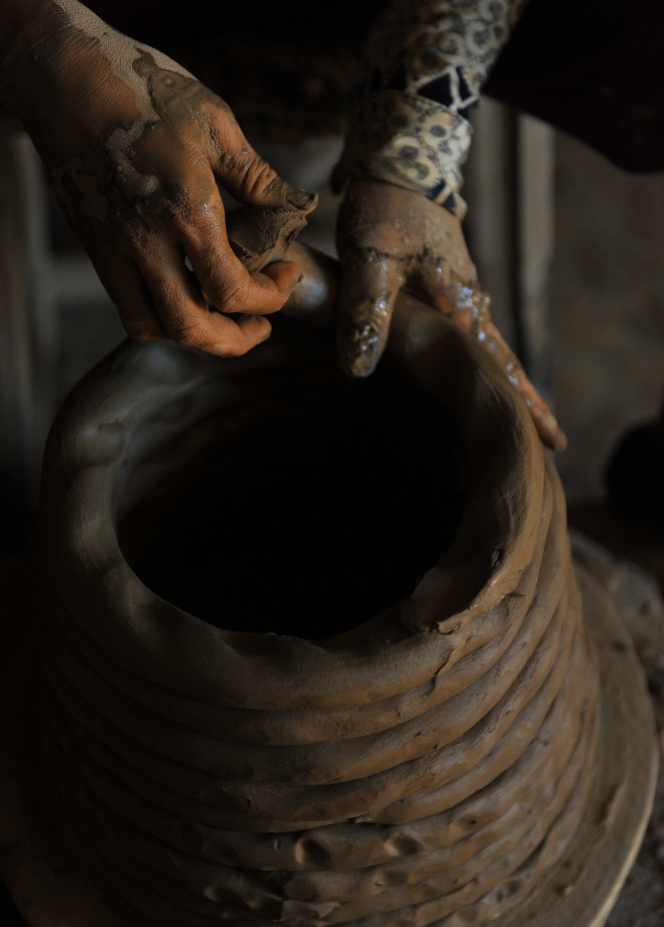 Tùy thuộc vào từng loại sản phẩm mà người thợ sẽ nặn đất theo mẫu khác nhau. Thông thường để làm ra những chiếc vò, chum, vại người thợ sẽ nặn đất thành những thớ dài và tròn để khi đưa lên bàn xoay ghép lại với nhau được dễ dàng hơn. (Ảnh: Minh Đức/TTXVN)