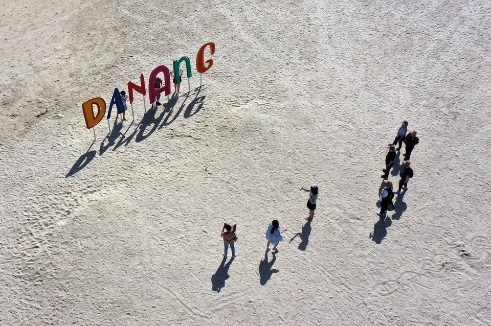 Khách du lịch vui chơi chụp ảnh trên biển Đà Nẵng. (Ảnh: Trần Lê Lâm/TTXVN)