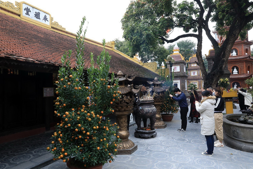 Người dân đến vãn cảnh và dâng hương tại chùa Trấn Quốc, quận Tây Hồ, Hà Nội. (Ảnh: Tuấn Anh/TTXVN)